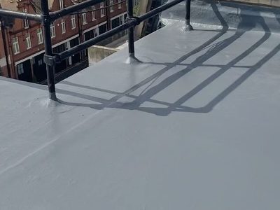 Grey flat rooftop surface with black railings casting shadows.